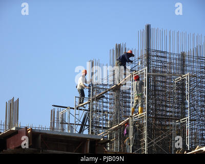 Les travailleurs de la construction de l'installation de la barre de renfort sur le chantier de construction. La barre de renfort est l'élément principal pour le renforcement du béton. Banque D'Images