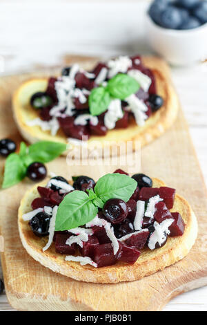 Les betteraves cuites avec bruschetta, bleuets, fromage feta, basilic et balsamique. Snack gastronomique. Régime alimentaire sain. Selective focus Banque D'Images