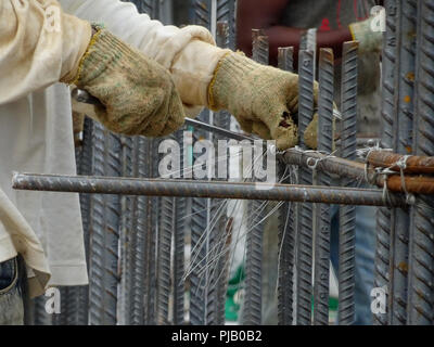 Les travailleurs de la construction de l'installation de la barre de renfort sur le chantier de construction. La barre de renfort est l'élément principal pour le renforcement du béton. Banque D'Images