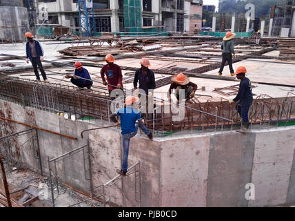 Les travailleurs de la construction de l'installation de la barre de renfort sur le chantier de construction. La barre de renfort est l'élément principal pour le renforcement du béton. Banque D'Images