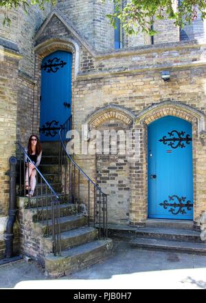 Une jeune fille assise sur une étape de l'église à Windsor. Banque D'Images