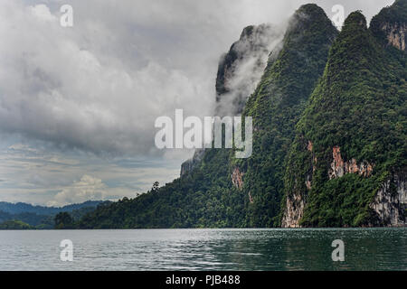 Formations karstiques et luxuriante forêt tropicale entourent Chiew Lan Lake Lac Cheow Lan ou le parc national de Khao Sok, Thaïlande Banque D'Images