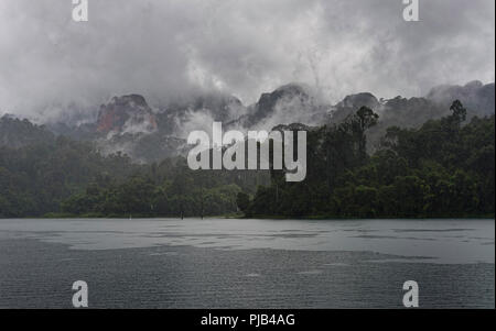 Formations karstiques et luxuriante forêt tropicale entourent Chiew Lan Lake Lac Cheow Lan ou le parc national de Khao Sok, Thaïlande Banque D'Images