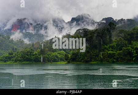 Formations karstiques et luxuriante forêt tropicale entourent Chiew Lan Lake Lac Cheow Lan ou le parc national de Khao Sok, Thaïlande Banque D'Images