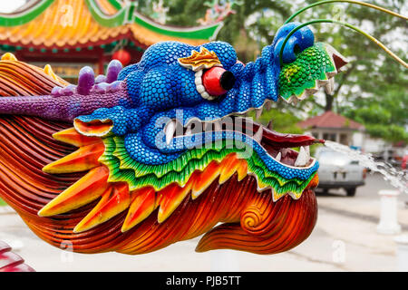 Un beau gros plan d'une pulvérisation d'eau tête de dragon à un temple chinois. Le jet d'eau sort de sa langue maternelle. Banque D'Images