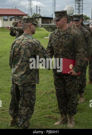 Le Caporal des Marines des États-Unis. Jonathan Hovet, un technicien de la motorisation avec des Groupe de travail air-sol marin - région Sud, serre la main avec le Colonel Michael H. Oppenheim, commandant du SPMAGTF-SC, au cours d'une cérémonie de promotion sur la base aérienne de Soto Cano, le Honduras, le 1 juillet 2018. Les Marines et les marins d'SPMAGTF-SC mènent la coopération de sécurité et de formation projets d'ingénierie avec des forces militaires de la nation d'Amérique centrale et du Sud. L'unité est également prêt à fournir une aide humanitaire et des secours en cas d'ouragan ou de toute autre urgence en th Banque D'Images