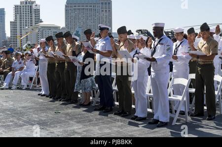 SAN DIEGO (3 juillet 2018) les membres de réciter le serment de citoyenneté lors d'une cérémonie de naturalisation sur le pont de l'USS Midway Museum. Quarante-neuf membres du service et les conjoints des militaires de 19 pays sont devenus citoyens américains durant la cérémonie parrainée par le U.S. Citizenship and Immigration Services. Banque D'Images