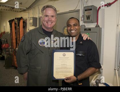 NORFOLK, Virginie (9 juillet 2018) Hospital Corpsman 1re classe Amarpreet Gill, de New York, affectés à l'USS Gerald R. Ford (CVN 78) service médical, reçoit son certificat de nomination au grade de maître de première classe du capitaine Richard McCormack, commandant du Ford. Gill a été promu après sa sélection pour le programme d'avancement méritoires. Banque D'Images