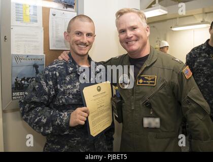 NORFOLK, Virginie (9 juillet 2018) Hospital Corpsman 2e classe Matthieu Tipton, de Gray, Kansas, affectés à l'USS Gerald R. Ford (CVN 78) service médical, reçoit son certificat de nomination au grade de maître de deuxième classe du capitaine Richard McCormack, commandant du Ford. Tipton a été promu après sa sélection pour le programme d'avancement méritoires. Banque D'Images