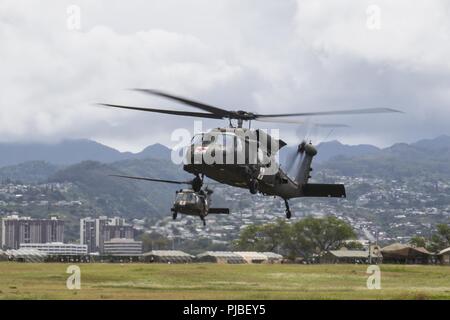 JOINT BASE HICKAM-PEARL HARBOR (11 juillet 2018) Deux hélicoptères UH-60 Black Hawk pour des terres de ravitaillement chaud au cours de l'assistance humanitaire pour les secours en cas de formation au cours de l'exercice Rim of the Pacific (RIMPAC) Le 11 juillet. Vingt-cinq nations, 46 navires, 5 sous-marins, environ 200 avions et 25 000 personnes participent à l'EXERCICE RIMPAC du 27 juin au 2 août dans et autour des îles Hawaï et la Californie du Sud. Le plus grand exercice maritime international RIMPAC, fournit une formation unique alors que la promotion et le soutien de relations de coopération entre les participants des Banque D'Images