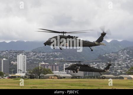 JOINT BASE HICKAM-PEARL HARBOR (11 juillet 2018) Deux hélicoptères UH-60 Black Hawk de quitter un poste de ravitaillement chaud au cours de l'assistance humanitaire pour les secours en cas de formation au cours de l'exercice Rim of the Pacific (RIMPAC) Le 11 juillet. Vingt-cinq nations, 46 navires, 5 sous-marins, environ 200 avions et 25 000 personnes participent à l'EXERCICE RIMPAC du 27 juin au 2 août dans et autour des îles Hawaï et la Californie du Sud. Le plus grand exercice maritime international RIMPAC, fournit une formation unique alors que la promotion et le soutien de relations de coopération entre les particip Banque D'Images