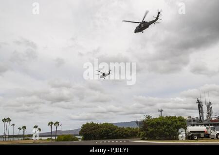 JOINT BASE HICKAM-PEARL HARBOR (11 juillet 2018) Deux hélicoptères UH-60 Black Hawk de quitter un poste de ravitaillement chaud au cours de l'assistance humanitaire aux sinistrés de la formation dans le cadre du Rim of the Pacific (RIMPAC) exercice 2018. Vingt-cinq nations, 46 navires, 5 sous-marins, environ 200 avions et 25 000 personnes participent à l'EXERCICE RIMPAC du 27 juin au 2 août dans et autour des îles Hawaï et la Californie du Sud. Le plus grand exercice maritime international RIMPAC, fournit une formation unique alors que la promotion et le soutien de relations de coopération entre les participants Banque D'Images