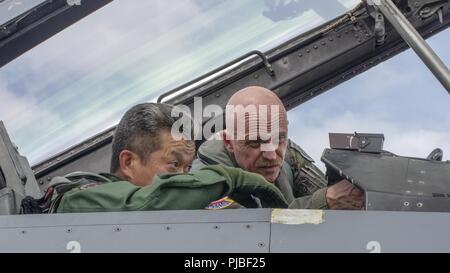 Japan Air Self-Defense Force le général de Kenichi Samejima, gauche, la 3e escadre de l'air, écoute U.S. Air Force Colonel R. Scott Jobe, droite, la 35e Escadre de chasse, d'expliquer la mécanique de l'avion avant qu'un F-16 Fighting Falcon vol de familiarisation à Misawa Air Base, Japon, le 2 juillet 2018. Ce vol autorisé Samejima, un pilote de F-2, l'occasion de découvrir les capacités de l'avion, en fin de compte permettant à un partenaire une mission critique pour mieux comprendre comment les forces de l'air USAF et JASDF s'imbriquent et se complètent les uns les autres dans la défense mutuelle du Japon. Banque D'Images