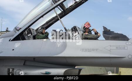 Japan Air Self-Defense Force le général de Kenichi Samejima, gauche, la 3e, commandant de l'Escadre aérienne de la Force aérienne des États-Unis et le Colonel R. Scott Jobe, droite, la 35e Escadre de chasse, préparez-vous au décollage avant d'un F-16 Fighting Falcon vol de familiarisation à Misawa Air Base, Japon, le 2 juillet 2018. Le vol de familiarisation a donné Samejima, un pilote de F-2, l'occasion de découvrir les responsabilités du F-16 Fighting Falcon. Banque D'Images