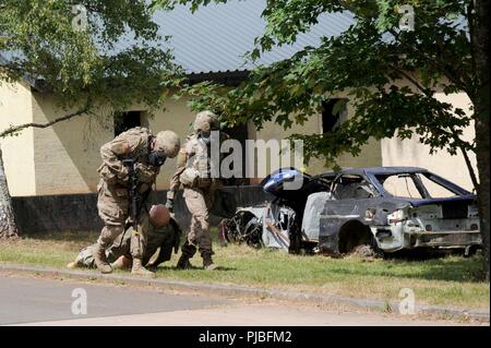 Le Sgt. Shuntaneque Greenwald, U.S. Army, Brigade de l'OTAN et le Sgt. Goehle Nelson évacuer une victime simulée pendant le 21e soutien Théâtre de la situation Commande d'entraînement sur les opérations militaires Terrain urbain Site. Dix-huit concurrents à partir de la 21e à la concurrence commande Soutien Théâtre gagner le titre de "Meilleur guerrier'. Baumholder, Allemagne, 9 juillet 2018 Banque D'Images