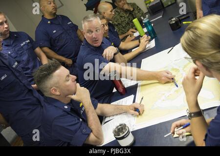 PEARL HARBOR (10 juillet 2018) Capitaine John Driscoll, commandant de l'USCGC Bertholf (WMSL 750), est titulaire d'un mémoire de navigation avec son équipage le 10 juillet 2018, en préparation de départ de Pearl Harbor à l'appui de l'exercice RIMPAC 2018. Vingt-cinq nations, plus de 46 navires et sous-marins, 5 sur 200 avions et 25 000 personnes participent à l'EXERCICE RIMPAC du 27 juin au 2 août dans et autour de l'île hawaïenne et du sud de la Californie. Le plus grand exercice maritime international RIMPAC, fournit une formation unique alors que la promotion et le soutien de relations de coopération entre les p Banque D'Images