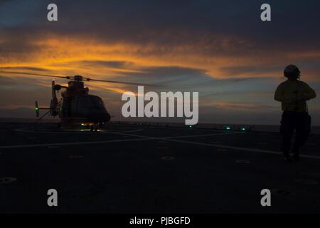Océan Pacifique (10 juillet 2018) Un hélicoptère MH-65 de Dolphin Coast Guard Air Station Point, New York, barbiers se prépare à décoller le 10 juillet 2018, sur le pont de vol Le USCGC Bertholf (WMSL 750), 15 km au sud d'Oahu dans l'appui de l'exercice RIMPAC 2018. Vingt-cinq nations, plus de 46 navires et sous-marins, 5 sur 200 avions et 25 000 personnes participent à l'EXERCICE RIMPAC du 27 juin au 2 août dans et autour de l'île hawaïenne et du sud de la Californie. Le plus grand exercice maritime international RIMPAC, fournit une formation unique tout en favorisant et soutenant cooperativ Banque D'Images