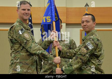 Le major Tito Ruiz, droite, accepte le commandement de l'Escadron de soutien de sécurité 1341e depuis le colonel Aaron Guill, 341e commandant du Groupe des forces de sécurité au cours d'une cérémonie de passation de commandement le 12 juillet 2018, à l'ours Grizzly Bend sur la base aérienne de Malmstrom, au Montana, Guidon maître au porteur le Sgt. Alejandro Torres, 341e first sergeant SSPTS, regarde. Banque D'Images