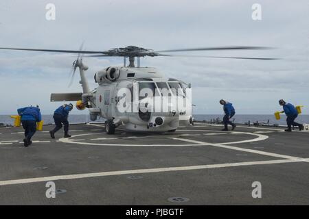 Océan Pacifique (11 juillet 2018) l'équipage de la Garde côtière canadienne se déplacer sur le pont de vol Le USCGC Bertholf (WMSL 750) le 11 juillet 2018, d'obtenir un hélicoptère de la Force japonaise d'autodéfense maritime navire hélicoptère destroyer DDH 182 JS (ISE) à environ 15 milles au sud-ouest d'Oahu, Hawaii, à l'appui de l'exercice RIMPAC 2018. Vingt-cinq nations, plus de 46 navires et 5 sous-marins, environ 200 avions et 25 000 personnes participent à l'EXERCICE RIMPAC du 27 juin au 2 août dans et autour de l'île hawaïenne et du sud de la Californie. Le plus grand exercice maritime international RIMPAC, fournit Banque D'Images
