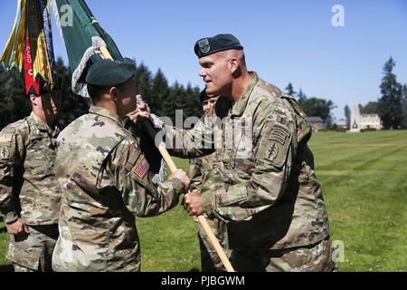 Le major-général John E. Deedrick, Jr., the 1st Special Forces du général commandant la commande passe le 1st Special Forces Group (Airborne) couleurs de l'unité au colonel Owen G. Ray signalant le transfert de commandement entre le colonel Guillaume N. Beaurpere at Joint Base Lewis-McChord, le 11 juillet. L'adoption de la couleurs de l'unité sert de point précis dans le temps de la responsabilité de commandement, pour passer de l'ancien au nouveau commandant. L'unité couleurs représentent le patrimoine et l'histoire de l'unité et il représente également le symbole de l'autorité du commandant. Banque D'Images