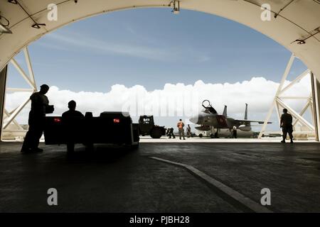 Aviateurs de la 67e Unité de maintenance d'aéronefs remorquer un F-15C Eagle en préparation de typhon maria le 9 juillet 2018, à Kadena Air Base, au Japon. Les responsables de l'équipe de Kadena déplacé vers les abris de protection pour empêcher les dommages des phénomènes météorologiques. Banque D'Images