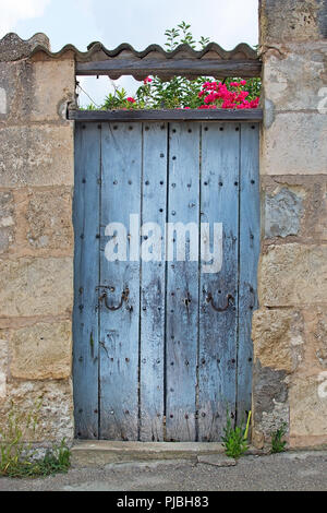 Bleu rustique ancien porte en bois avec toit de tuiles et de bougainvilliers roses à Mallorca, Espagne. Banque D'Images