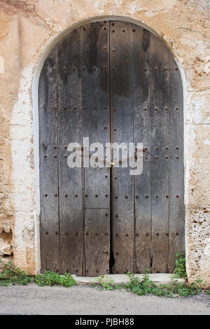 Brun rustique en bois avec porte voûtée sur cadenas stone building in Mallorca, Espagne. Banque D'Images