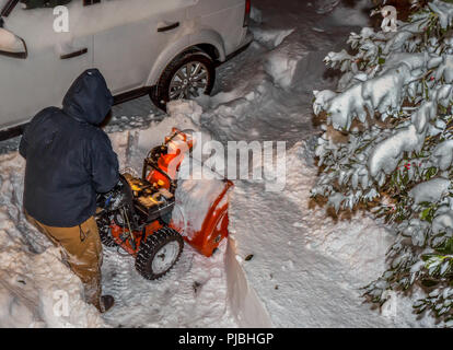 Effacement de l'homme son allée avec une souffleuse à neige pendant un blizzard Banque D'Images