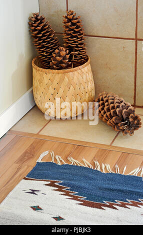Grandes pommes de pin à sucre en bambou tressé panier et tapis tissé à la couleur ajouter un naturel rustique chaleureux accent à un angle d'une pièce Banque D'Images