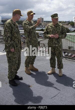 PEARL HARBOR (6 juillet 2018) Vice-amiral. John D. Alexander (à droite), commandant de la flotte américaine, 3e, parle avec l'installation de traitement médical USNS Mercy (T-AH 19) Commandant, le capitaine John R. Rotruck (à gauche), et le Capitaine Peter Roberts, chirurgien américain flotte au cours de la 3ème exercice Rim of the Pacific, le 6 juillet. Vingt-cinq nations, 46 navires, 5 sous-marins, environ 200 avions et 25 000 personnes participent à l'EXERCICE RIMPAC du 27 juin au 2 août dans et autour des îles Hawaï et la Californie du Sud. Le plus grand exercice maritime international RIMPAC, fournit une formation unique whi Banque D'Images