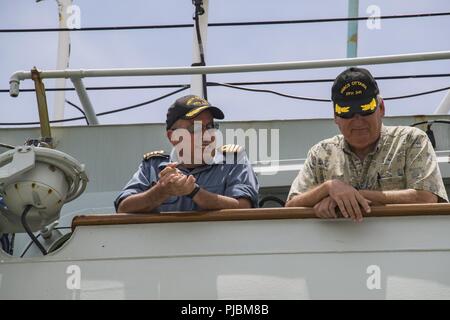 PEARL HARBOR (10 juillet 2018) Le commandant Alex Barlow, Commandant de la frégate de la Marine royale canadienne, le NCSM Ottawa (FF 341) parle avec le capitaine que le navire se prépare à glisser le long d'une base commune pour entamer le Harbor-Hickam Pearl en mer phase de la Rim of the Pacific (RIMPAC) exercice 2018. Vingt-cinq nations, 46 navires, 5 sous-marins, environ 200 avions et 25 000 personnes participent à l'EXERCICE RIMPAC du 27 juin au 2 août dans et autour des îles Hawaï et la Californie du Sud. Le plus grand exercice maritime international RIMPAC, fournit une formation unique opp Banque D'Images