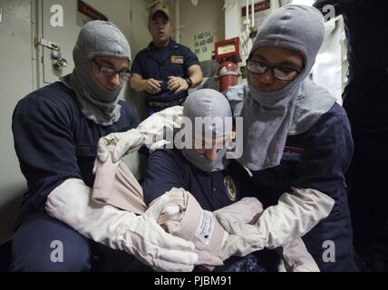 Mer des Philippines (10 juillet 2018) Techniciens Sonar (Surface) 2e classe Princes sonores, droite et gauche, Mark Lamm, fournir l'aide d'un technicien de surface (Sonar) Seaman Wingrove Dakota durant un exercice général quarts à bord de la classe Arleigh Burke destroyer lance-missiles USS Benfold (DDG 65). Benfold est l'avant-déployés dans la 7e flotte américaine zone d'opérations à l'appui de la sécurité et de la stabilité dans la région Indo-Pacifique. Banque D'Images