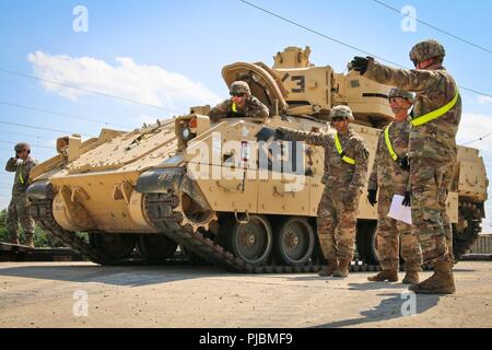 Des soldats d'un Co., 2e Bataillon, 5e régiment de cavalerie, 1st Armored Brigade Combat Team, 1re Division de cavalerie de discuter de procédures pour télécharger des véhicules qui sont arrivés en tête de ligne de Zimnitsa, la Bulgarie, le 2 juillet 2018. Les véhicules sont arrivés à partir de la Ft Hood au Texas, et est arrivé en Europe au port d'Anvers, Belgique. Banque D'Images