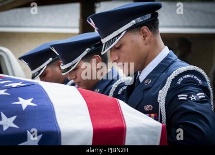 Kevin Navigant de première classe Fortuna-Suarez, 96e Escadron de soutien de la Force aérienne, aide les autres porteurs honoraires déposer le cercueil d'un corbillard au cours de la cérémonie de remise des diplômes de la garde d'honneur le 9 juillet à la base aérienne d'Eglin, en Floride, environ 14 nouveaux aviateurs est diplômé de l'-plus 120 heures de cours. L'obtention du diplôme l'exécution est le détail du pavillon, carabine volley, porteurs et clairon pour les amis, la famille et les chefs de service. Banque D'Images