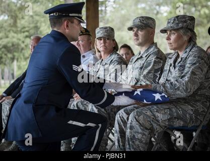 Airman Senior Zachary Brady, 96e Groupe médical, présente un drapeau au colonel Denise Edwards, 96e Escadre d'essai, au cours de la cérémonie de remise des diplômes de la garde d'honneur le 9 juillet à la base aérienne d'Eglin, en Floride, environ 14 nouveaux aviateurs est diplômé de l'-plus 120 heures de cours. L'obtention du diplôme l'exécution est le détail du pavillon, carabine volley, porteurs et clairon pour les amis, la famille et les chefs de service. Banque D'Images