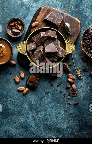 Morceaux de chocolat concassé et fèves de cacao. Fond Chocolat Banque D'Images