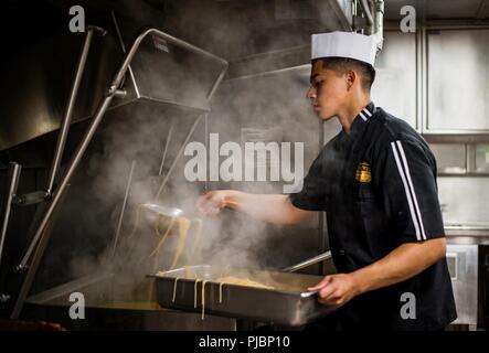 Océan Pacifique (12 juillet 2018) - Spécialiste culinaire Seaman Rigo Sandoval, de Los Angeles, boules nouilles dans une casserole avant de déjeuner à bord du destroyer lance-missiles USS Dewey (DDG 105). Dewey est en cours participant à l'exercice Rim of the Pacific (RIMPAC). Vingt-cinq nations, 46 navires, 5 sous-marins, environ 200 avions et 25 000 personnes participent à l'EXERCICE RIMPAC du 27 juin au 2 août dans et autour des îles Hawaï et la Californie du Sud. Le plus grand exercice maritime international RIMPAC, fournit une formation unique alors que la promotion et le soutien de l'exploitation Banque D'Images