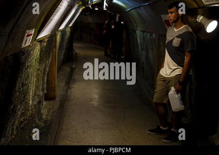 Lance le Cpl. Taylor Napier, opérateur d'équipement lourd avec du bataillon logistique de combat 31 et originaire de Dayton, Ohio, se lit un signe dans les tunnels de l'ancien siège de l'underground de La marine japonaise au cours d'une Marine Corps Community Services-parrainé guidée de quelques importants points d'intérêt dans le sud de l'Okinawa, Japon, Juillet 13, 2018. Napier est diplômé de l'École Belmont en mai 2016 avant de s'enrôler en juin de la même année. Les tunnels du siège situé près de 4 000 défenseurs japonais pendant la bataille d'Okinawa et ouvert au public comme un monument et mémorial en Banque D'Images