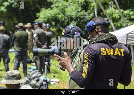 Un concurrent dominicaine calcule la vitesse du vent avant de régler son fusil de sniper pendant la mise à zéro des armes en préparation pour cette année, les Fuerzas Comando, Juillet 15, 2018 sur un champ de tir à Panama City, au Panama. Fuerzas Comando est une multinationale annuel forces opérationnelles spéciales compétences concours parrainé par le Commandement Sud des États-Unis et a accueilli cette année par le ministère de la Sécurité publique, au Panama. Grâce à une compétition amicale, cet exercice favorise l'interopérabilité, les relations militaires, l'augmentation des connaissances, formation et améliore la sécurité régionale. Banque D'Images