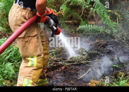 Membre de l'incendie et de secours de Suffolk combat un feu près de Brandon, en Angleterre, le 13 juillet 2018. Le Service d'incendie et de sauvetage de Suffolk a reçu l'appui de la 48e Escadron de génie civil à la Royal Air Force Lakenheath et autres services d'urgence dans la région. Banque D'Images