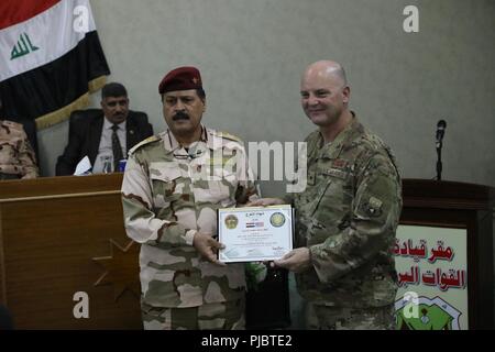 U.S. Air Force Brig. Le général James. R. Kriesel, Combined Joint Task Force - Fonctionnement résoudre inhérent de l'aviation de la Coalition Directeur de l'équipe de conseil et de formation, présente un certificat d'un diplômé de la formation de planificateurs Vocalis, qui enseigne l'Iraquien de mener informer, influencer et persuader les opérations, à Bagdad, l'Iraq, le 14 juillet 2018. Conseiller et assister les équipes sont l'activation est associé leurs forces pour vaincre ISIS en fournissant une formation et des conseils sur la planification opérationnelle militaire, manœuvre, d'intelligence et de l'appui de l'air sur le champ de bataille. Banque D'Images