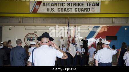 Les membres de la Joint Base McGuire-Dix-Lakehurst payer communauté leur respect pour le drapeau américain lors de l'hymne national à la Garde côtière des États-Unis l'équipe de choc de l'Atlantique cérémonie de passation de commandement, le Joint Base MDL, N.J., le 12 juillet 2018. Reconnu par la loi en 1931, tous les membres des forces armées et des anciens combattants militaires durant l'hymne national alors que les civils mettent leur main sur le coeur. Banque D'Images