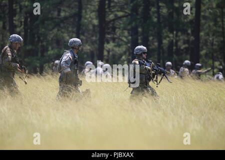 Les soldats de la Garde nationale de l'Armée américaine à partir de la Compagnie Bravo, 1er Bataillon, 114e d'infanterie (Air Assault) à pied la ligne de bois au cours d'une mission de formation de l'assaut aérien sur Joint Base McGuire-Dix-Lakehurst, N.J., le 16 juillet 2018. Banque D'Images