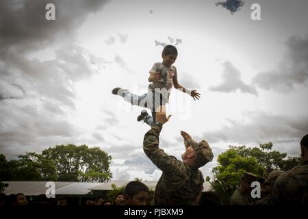 Le capitaine des Marines américain Tyler Settelen, l'élément logistique officier responsable avec des Groupe de travail air-sol marin - région Sud, joue avec un enfant guatémaltèque locale sur le site d'un projet dans la région de Flores, Guatemala, le 9 juillet 2018. Les Marines et les marins d'SPMAGTF-SC mènent la coopération de sécurité et de formation projets d'ingénierie avec des forces militaires de la nation d'Amérique centrale et du Sud. L'unité est également prêt à fournir une aide humanitaire et des secours en cas d'ouragan ou d'une autre situation d'urgence dans la région. Banque D'Images