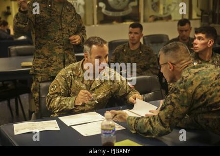 Le Capitaine de vaisseau chilien Jorge Keitel, gauche, un conseiller spécial avec des Groupe de travail air-sol marin - région Sud, parle aux U.S. Marine Le Colonel Michael H. Oppenheim, commandant du SPMAGTF-SC, lors d'un processus de planification d'intervention rapide bref avec les dirigeants de la marine à bord du USS Gunston Hall (LSD 44), le 13 juillet 2018. Dans une première historique, SPMAGTF-SC a intégré Keitel et le lieutenant-colonel d'infanterie de marine colombienne Erick Del Rio dans l'unité de commande du personnel. Les Marines et les marins d'SPMAGTF-SC mènent la coopération de sécurité et de formation projets d'ingénierie avec des nation Banque D'Images