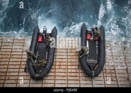 Marins australiens de se préparer pour la lutte contre le maraudage de plaisance en caoutchouc, à partir de l'arrière de la porte de quai navire de débarquement amphibie USS Harpers Ferry (LSD 49), le 17 juillet, à l'appui de la Rim of the Pacific (RIMPAC) dans l'océan Pacifique le 17 juillet 2018. Vingt-cinq nations, 46 navires, 5 sous-marins, environ 200 avions et 25 000 personnes participent à l'EXERCICE RIMPAC du 27 juin au 2 août dans et autour des îles Hawaï et la Californie du Sud. Le plus grand exercice maritime international RIMPAC, fournit une formation unique tout en renforçant et en soutenant les coopératives Banque D'Images