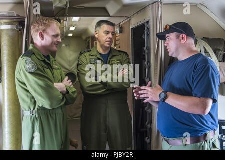 Océan Pacifique (16 juillet 2018) Royal Canadian Air Force Sgt. Mike Moffitt (droite), opérateur de détecteurs électroniques aéroportés (OP DEA), qui travaille à bord d'un Aurora canadien (CP 140), l'aéronef effectue une brève de sécurité pré-vol avec le Colonel Mike Atkins (centre), le sous-commandant de la composante aérienne, et le lieutenant-colonel Mark Mombourquette (à gauche), Directeur du Centre d'opérations aériennes combinées, au cours de l'exercice Rim of the Pacific (RIMPAC), le 15 juillet. Vingt-cinq nations, 46 navires, 5 sous-marins, environ 200 avions et 25 000 personnes participent à l'EXERCICE RIMPAC du 27 juin au 2 août dans et autour de l'H Banque D'Images