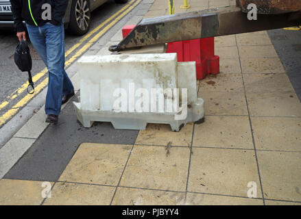 Les jambes d'âge moyen de négocier son chemin autour de la réparation des bollard en Bawtry, Angleterre Banque D'Images