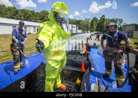 Membre de l'équipe d'enquête de l'armée américaine le Sgt. Joseph Bercovic, 21 armes de Destruction-Civil Équipe de soutien (21e ADM-CST), New Jersey, la Garde nationale est décontaminé par Morris Township les pompiers lors d'une coordination inter-agences de l'exercice au centre de technologie de la défense de patrie, Picatinny Arsenal, N.J., le 18 juillet 2018. Le 21e ADM-CST formés avec le New Jersey Army National Guard, 1ère du 150ème bataillon d'hélicoptères d'assaut ; le New Jersey Department of Corrections C.O.B.R.A. (Chimiques, biologiques, radiologiques, de munitions, de l'aide), l'unité de Picatinny Arsenal Pompiers, New Jersey Urgences Banque D'Images