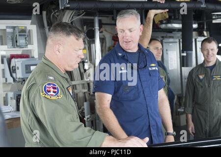 Océan Pacifique (Juillet 17, 2018) U.S. Coast Guard Capitaine John Driscoll (droite), commandant de l'US Coast Guard Cutter Bertholf (WMSL 750) traite de l'exploitation des navires avec le Capitaine de vaisseau Kevin Kennedy, le commodore du Pacifique aile HSC lors d'une visite à bord du Bertholf, 17 juillet. L'équipage de la marine de l'escadron de Black Knight CSS-4 est attribuée à l'Bertholf pour soutenir l'exercice RIMPAC 2018 exercices. Vingt-cinq nations, 46 navires, 5 sous-marins, environ 200 avions et 25 000 personnes participent à l'EXERCICE RIMPAC du 27 juin au 2 août dans et autour des îles Hawaï et du Sud Banque D'Images